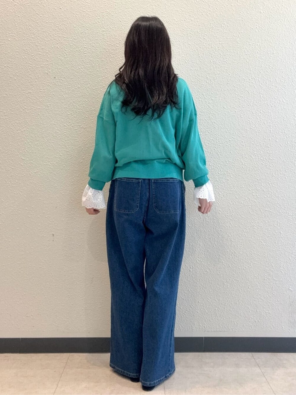 グリーン系のカーディガン/ボレロ、ホワイト系のシャツ/ブラウス、ブルー系のデニムパンツを着用したレディースの春コーディネートの2枚目の写真