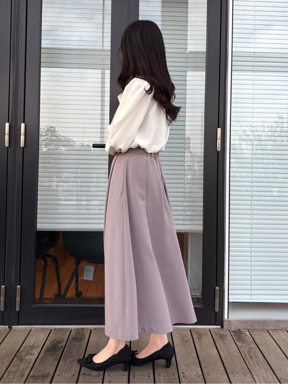 ベージュ系のシャツ/ブラウス、ブラウン系のスカート、ブラック系のハンドバッグを着用したレディースの春コーディネートの3枚目の写真