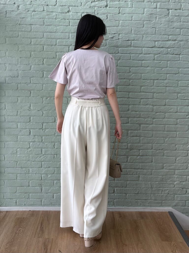 ピンク系のTシャツ/カットソー、ホワイト系のその他パンツ、ベージュ系のパンプスを着用したレディースの春コーディネートの4枚目の写真