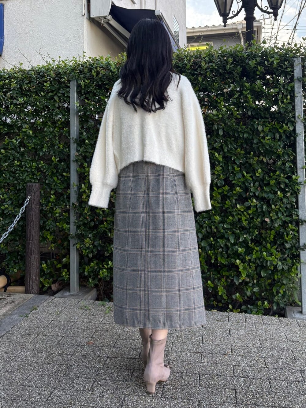 ホワイト系のカーディガン/ボレロ、ブラック系のワンピース、ベージュ系のブーツを着用したレディースの冬コーディネートの4枚目の写真
