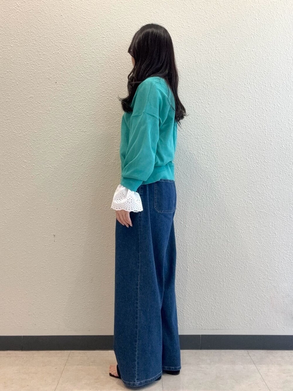 グリーン系のカーディガン/ボレロ、ホワイト系のシャツ/ブラウス、ブルー系のデニムパンツを着用したレディースの春コーディネートの3枚目の写真