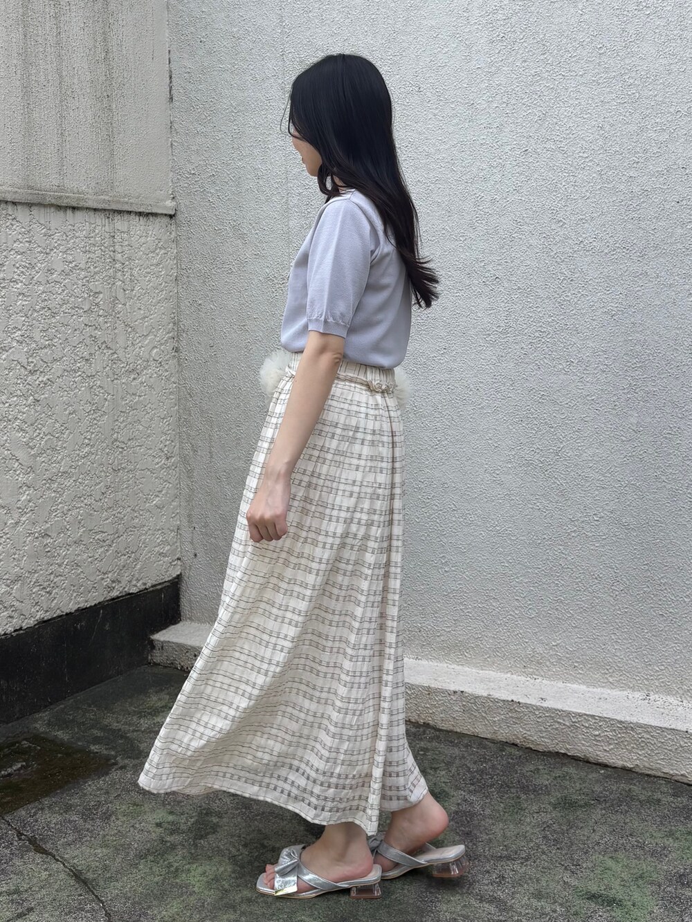 グレー系のニット/セーター、ホワイト系のスカート、シルバー系のサンダルを着用したレディースの夏コーディネートの2枚目の写真