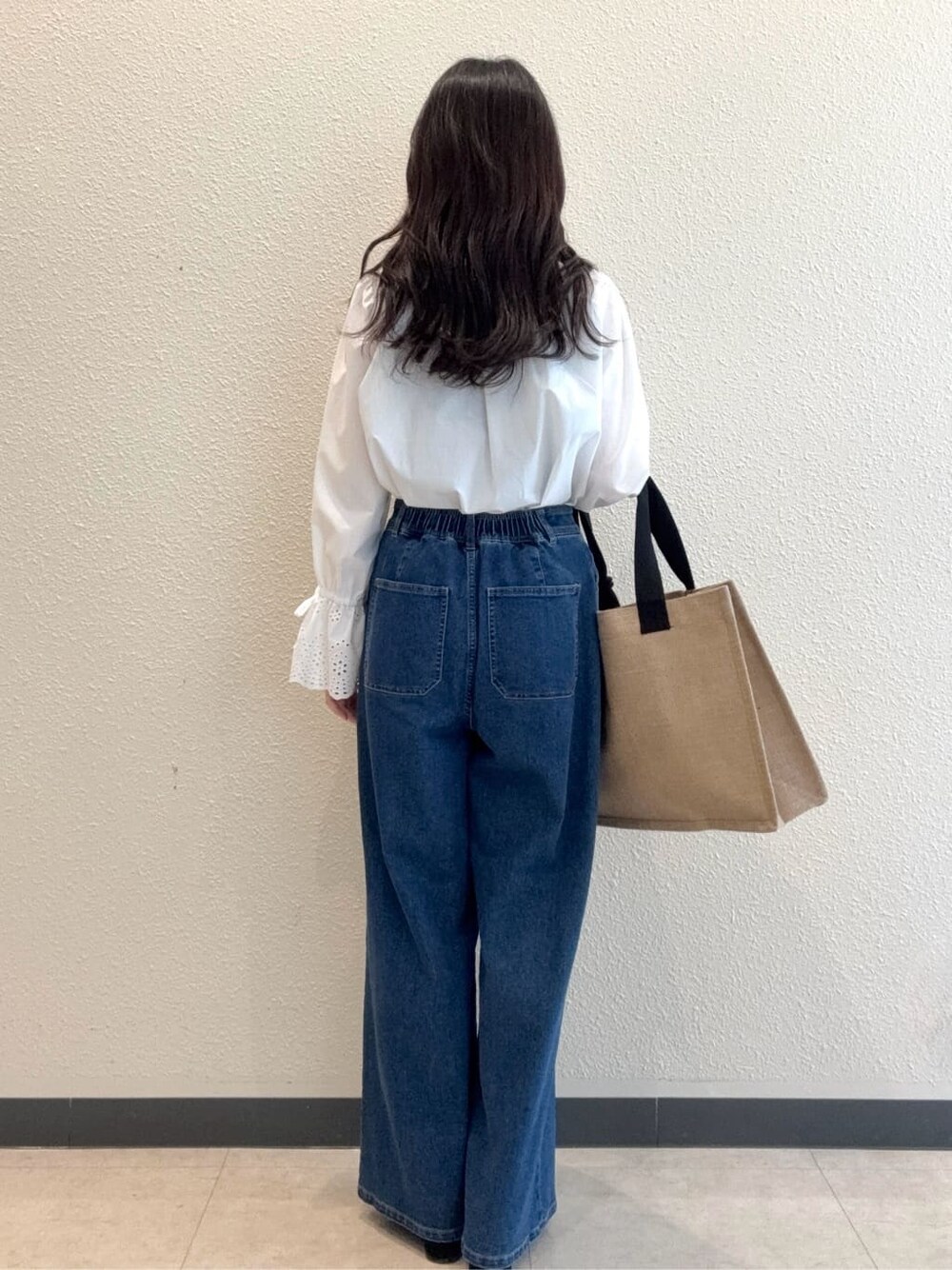 ホワイト系のシャツ/ブラウス、ブルー系のデニムパンツ、ブラック系のサンダルを着用したレディースの春コーディネートの2枚目の写真
