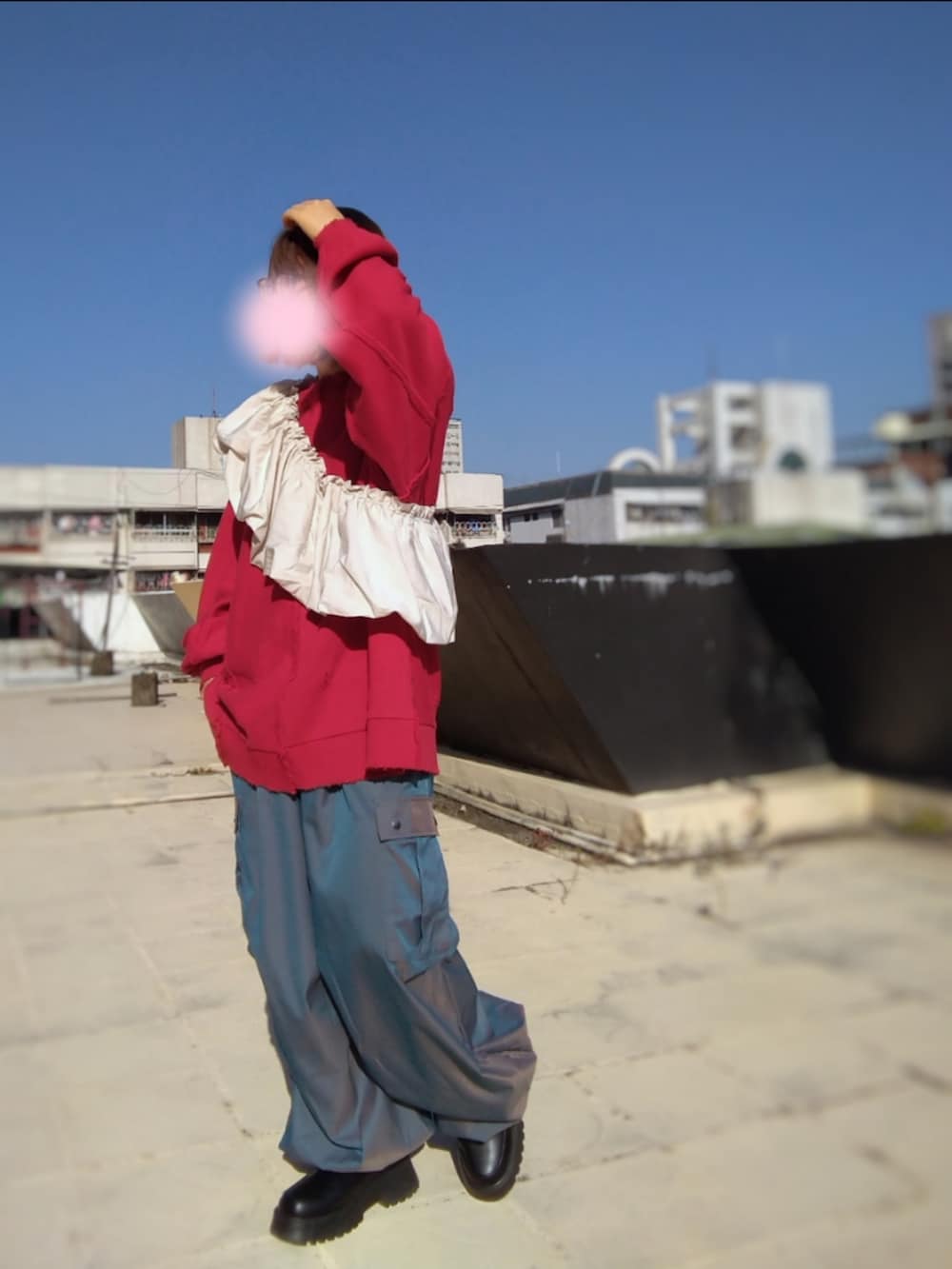 ブラック系のブーツ、ブルー系のカーゴパンツ、レッド系のスウェットを着用したレディースの秋コーディネートの2枚目の写真