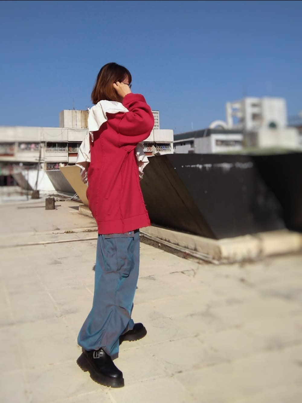 ブラック系のブーツ、ブルー系のカーゴパンツ、レッド系のスウェットを着用したレディースの秋コーディネートの3枚目の写真