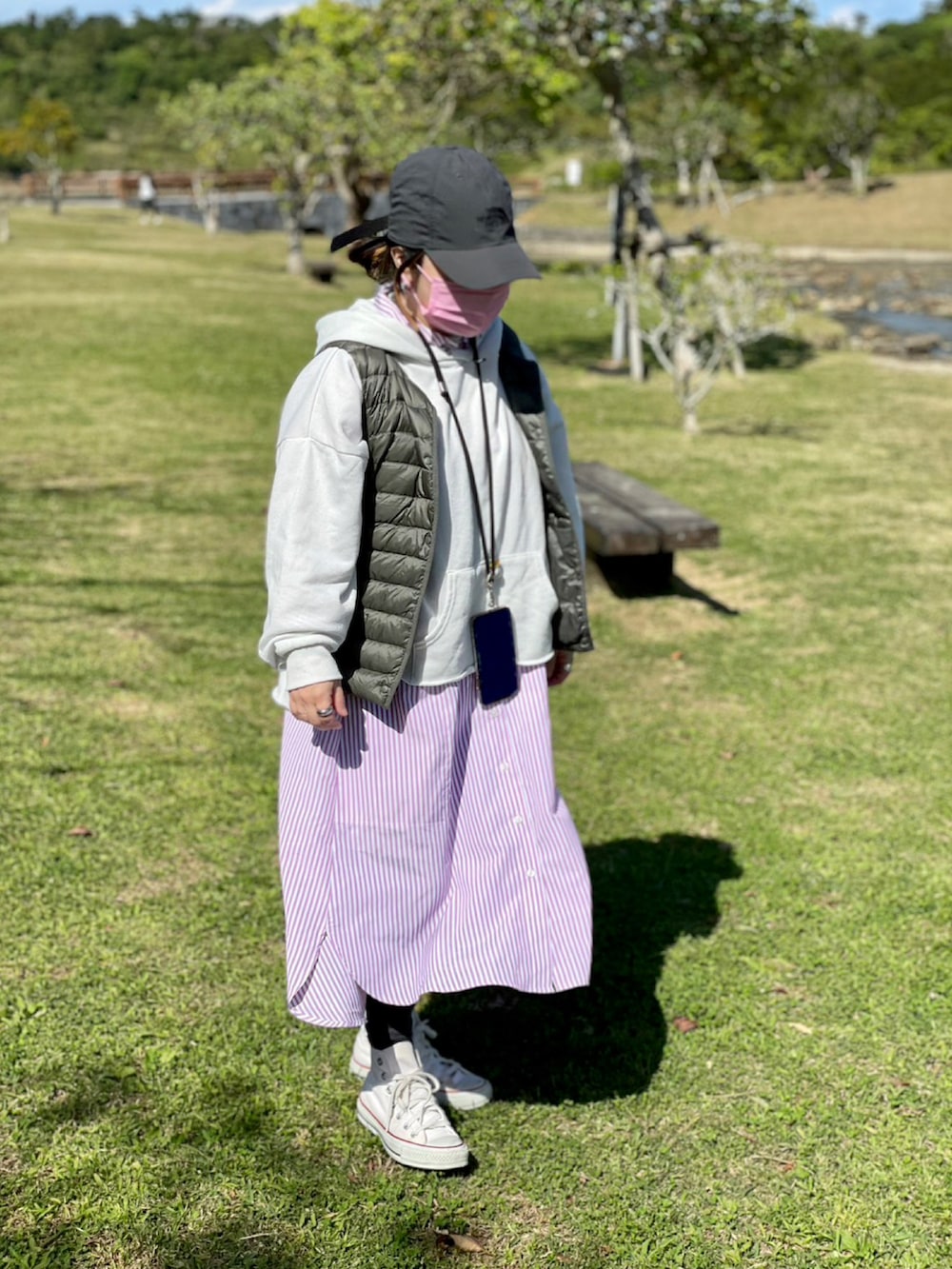 ホワイト系のスニーカー、ピンク系のシャツワンピース、ホワイト系のパーカーを着用したレディースの春コーディネートの2枚目の写真