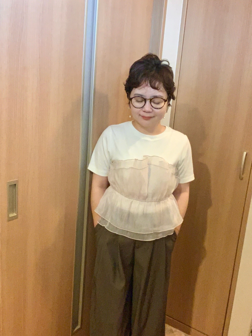 ブラック系のスニーカー、ホワイト系のTシャツ/カットソー、ブラウン系のスラックスを着用したレディースの秋コーディネートの3枚目の写真