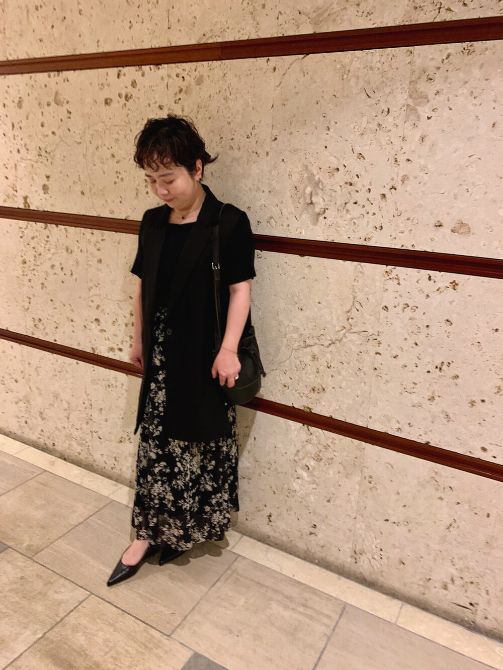 ブルー系のスカート、ブラック系のパンプス、ブラック系のショルダーバッグを着用したレディースの秋コーディネートの2枚目の写真