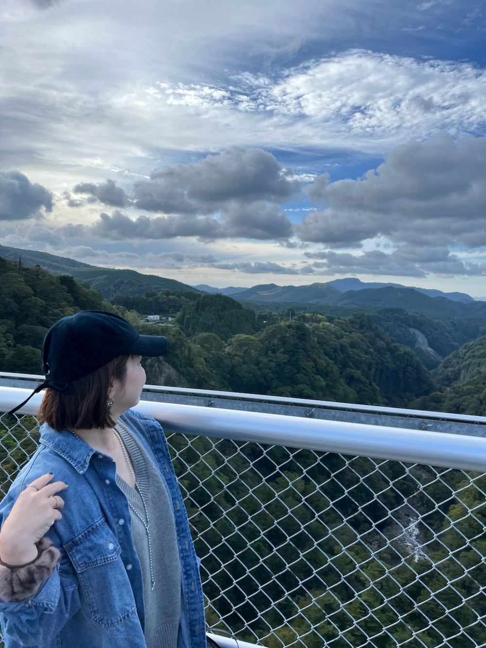 グリーン系のパンツ、グレー系のスニーカー、グレー系のベストを着用したレディースの秋コーディネートの2枚目の写真