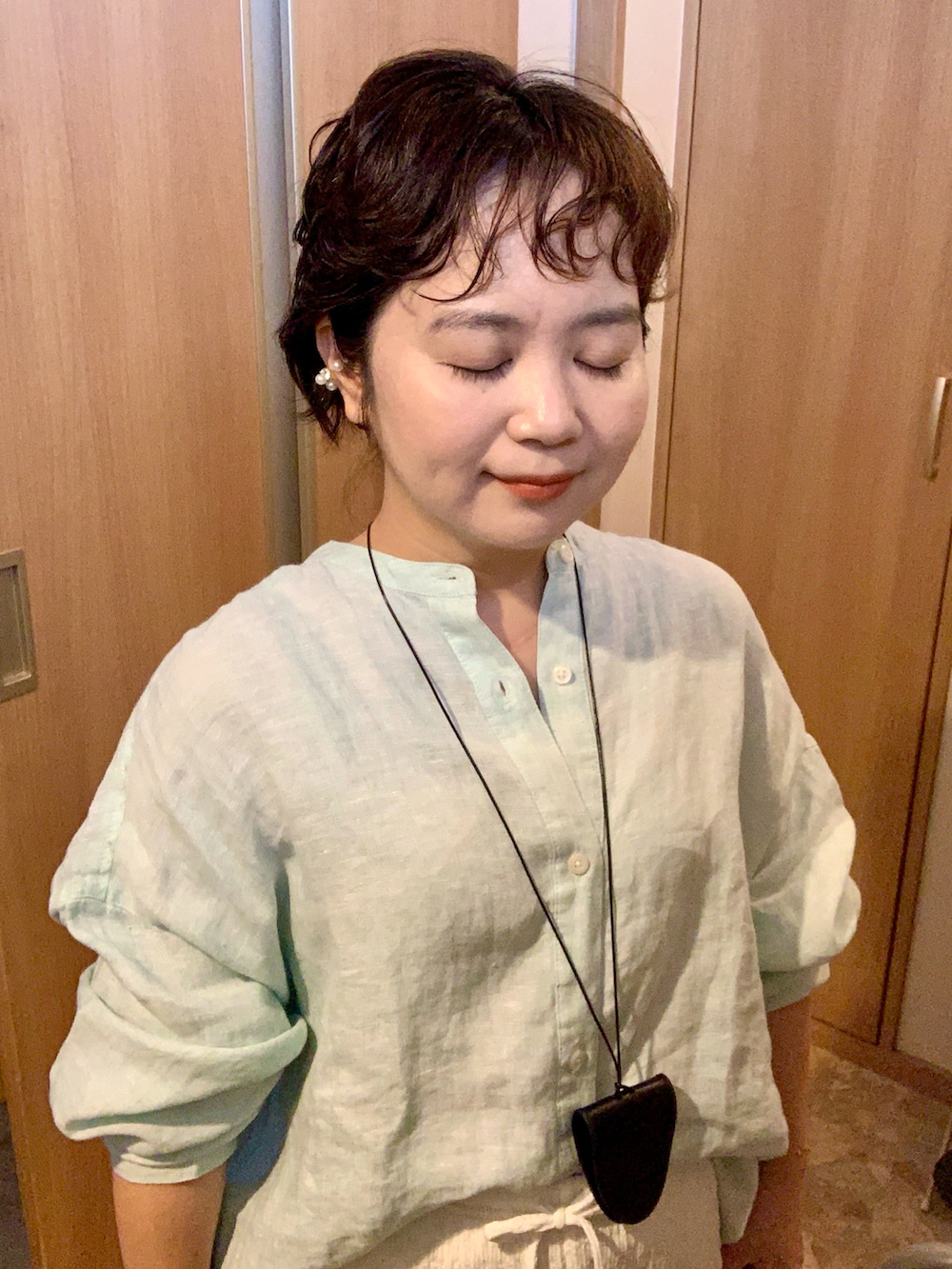 ホワイト系のパンツ、ホワイト系のパンプス、グリーン系のシャツ/ブラウスを着用したレディースの秋コーディネートの4枚目の写真