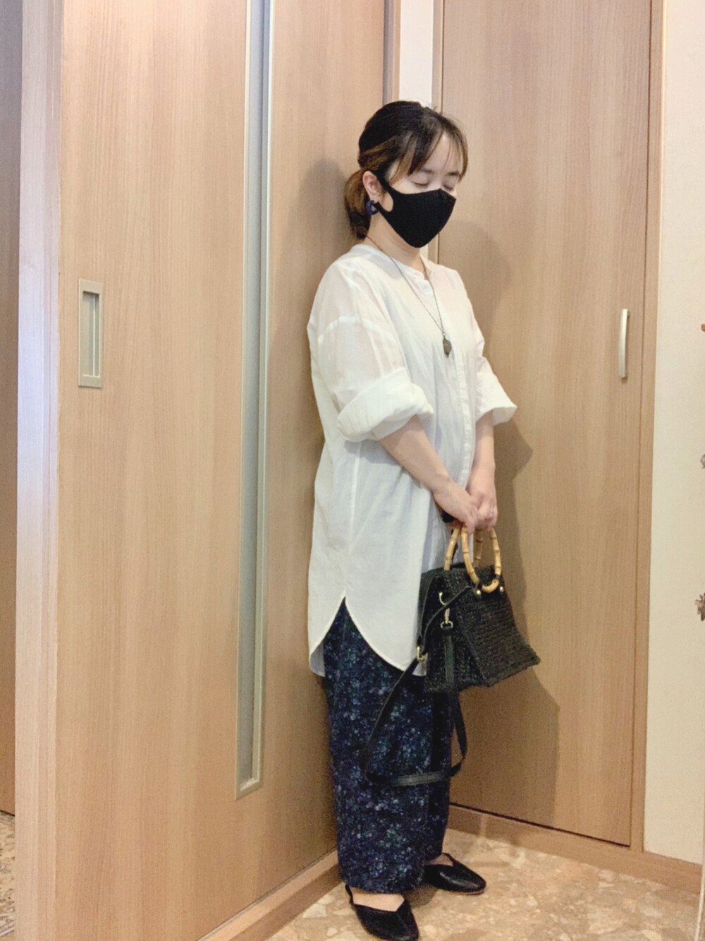 ブラック系のサンダル、ブルー系のパンツ、ブラック系のかごバッグを着用したレディースの秋コーディネートの2枚目の写真