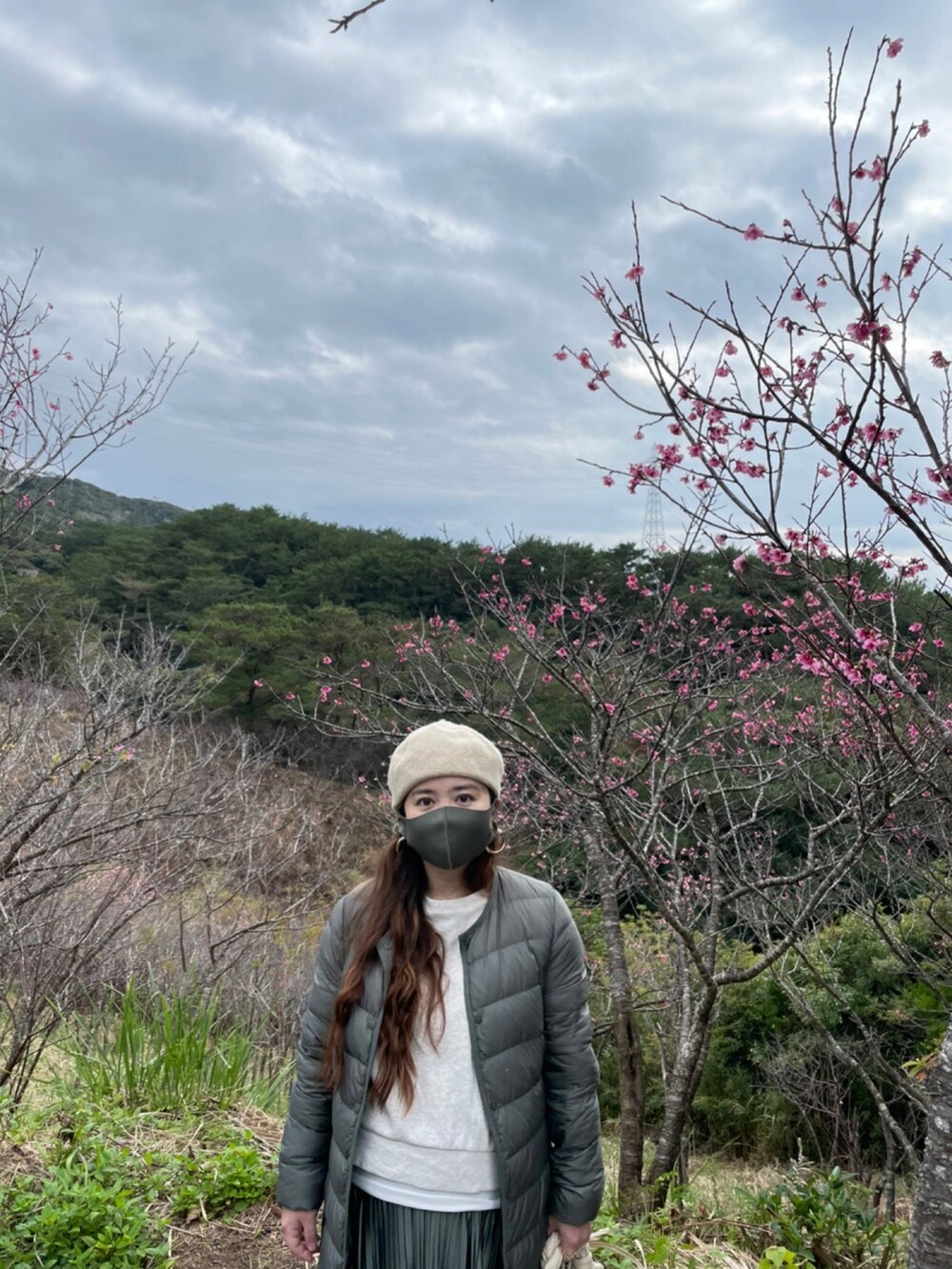 グリーン系のスカート、グリーン系のスニーカー、ホワイト系のスウェットを着用したレディースの冬コーディネートの4枚目の写真