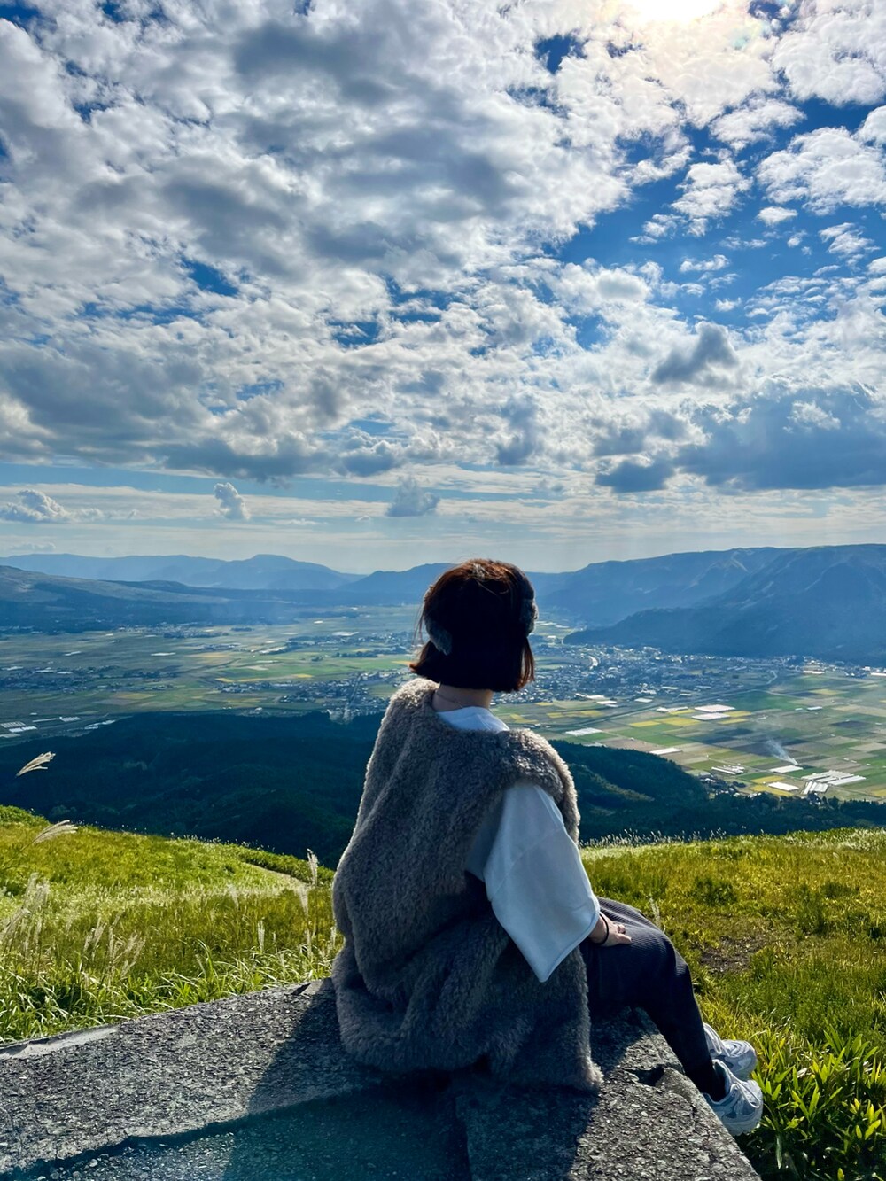 ホワイト系のスウェット、グレー系のスニーカー、グレー系のスカートを着用したレディースの秋コーディネートの2枚目の写真