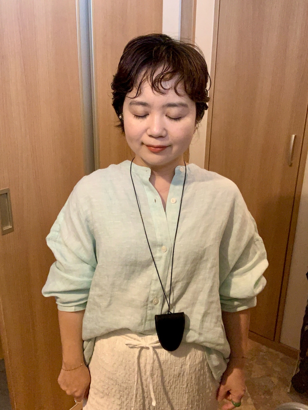 ホワイト系のパンツ、ホワイト系のパンプス、グリーン系のシャツ/ブラウスを着用したレディースの秋コーディネートの3枚目の写真