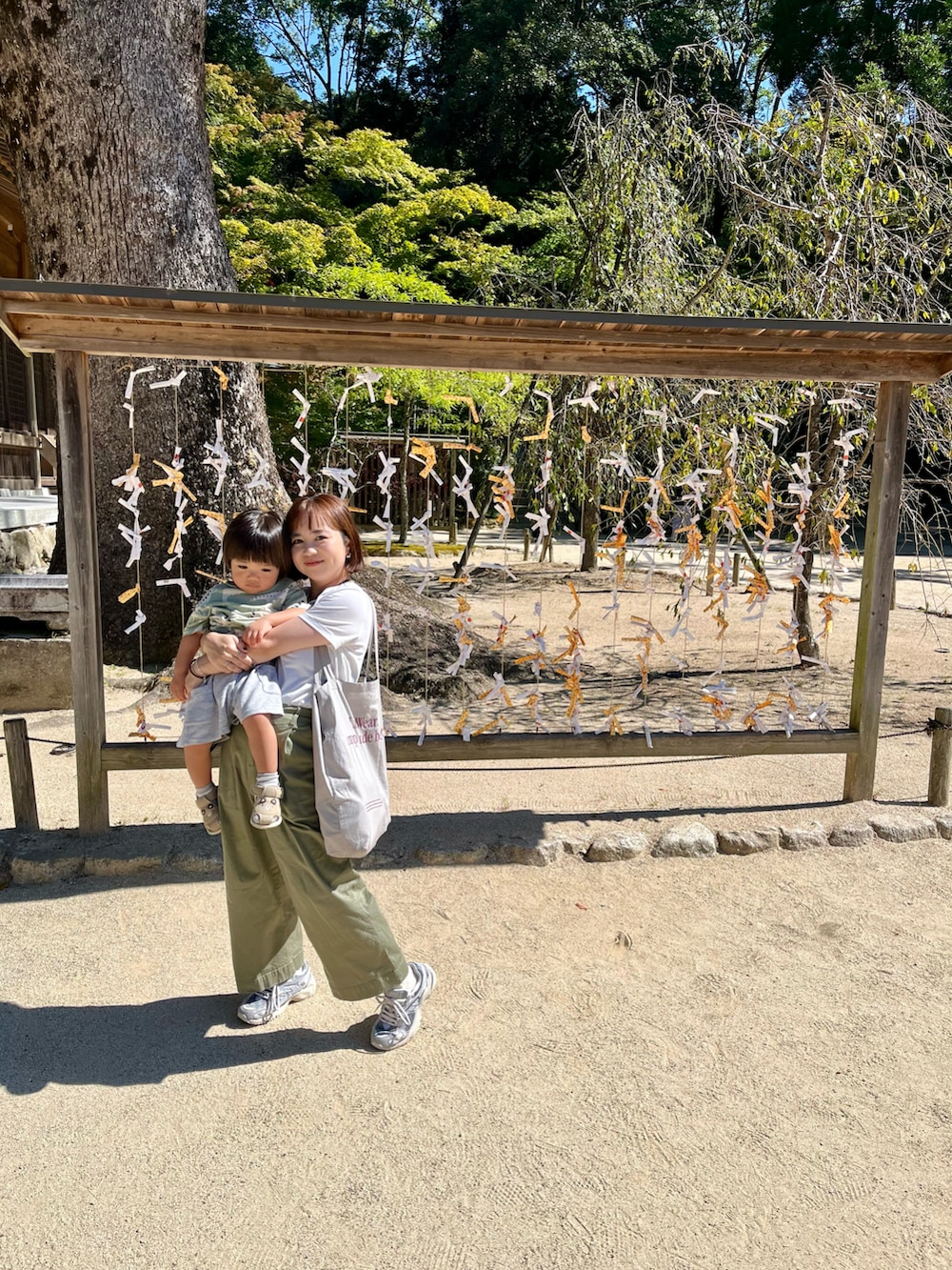 ホワイト系のTシャツ/カットソー、グリーン系のパンツ、グレー系のエコバッグ/サブバッグを着用したレディースの秋コーディネートの2枚目の写真