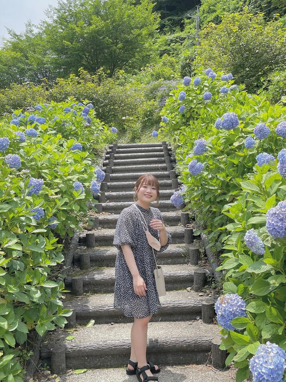 ブルー系のワンピース、ベージュ系のショルダーバッグを着用したレディースの秋コーディネートの2枚目の写真