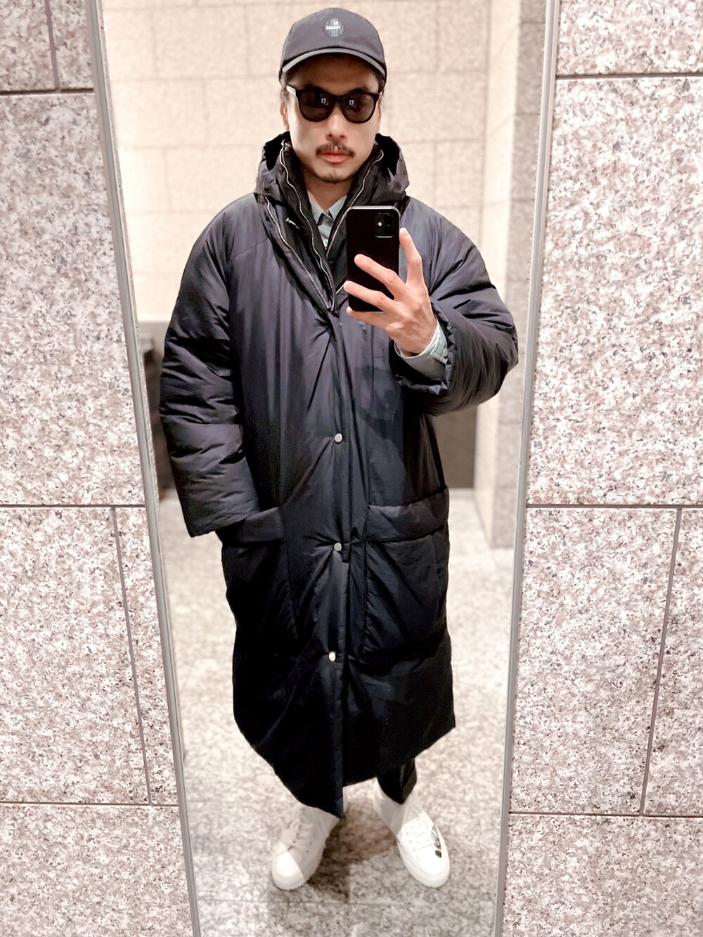 ブルー系のシャツ/ブラウス、ブラック系のダウンジャケット/コート、ホワイト系のスニーカーを着用したメンズの冬コーディネートの2枚目の写真