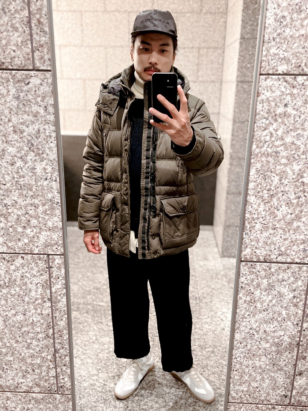 グリーン系のダウンジャケット/コート、ブラック系のその他パンツ、ホワイト系のハンドバッグを着用したメンズの冬コーディネートの3枚目の写真