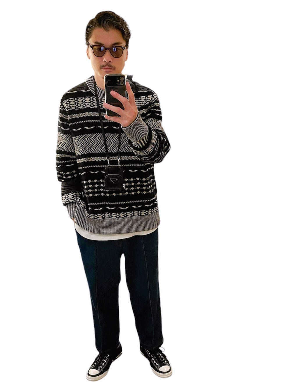 グリーン系のチェスターコート、ブラック系のスニーカー、ブラック系のスニーカーを着用したメンズの冬コーディネートの2枚目の写真