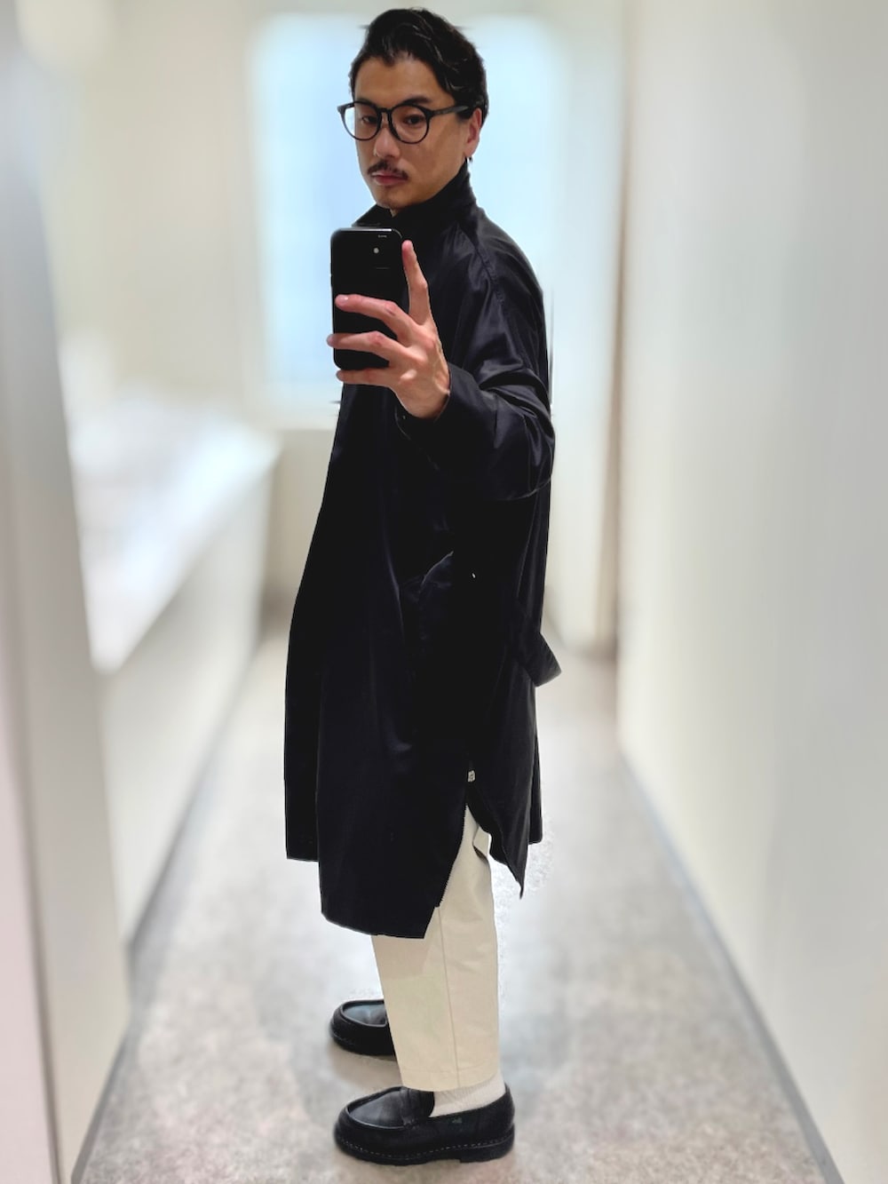 ブラック系のトートバッグ、ブラック系のドレスシューズ、ベージュ系のチノパンツを着用したメンズの春コーディネートの2枚目の写真