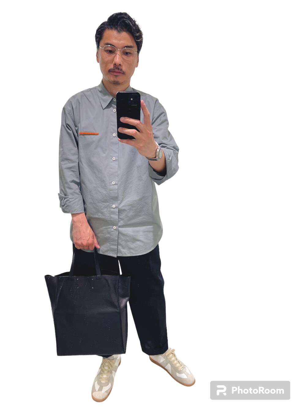 ホワイト系のスニーカー、ブルー系のシャツ/ブラウス、ブラック系のスラックスを着用したメンズの春コーディネートの2枚目の写真