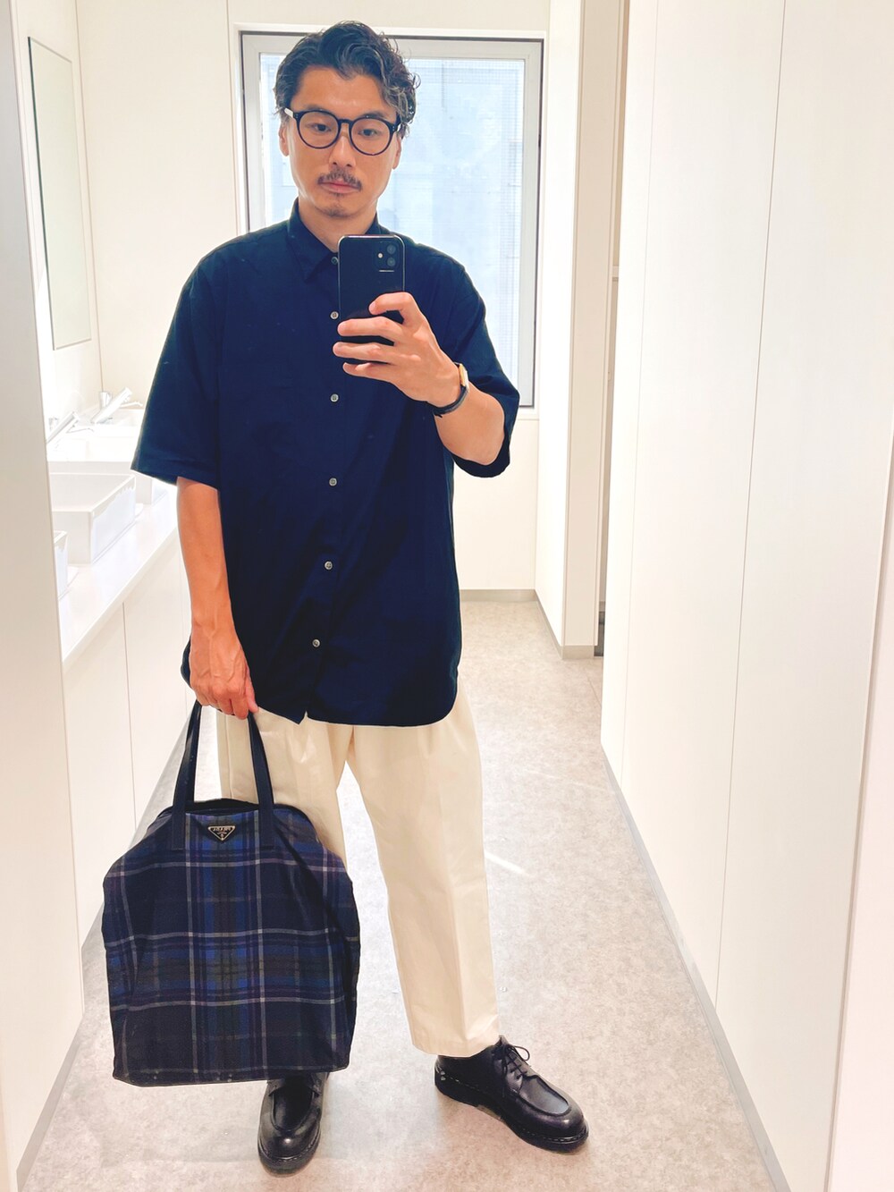 ベージュ系のチノパンツ、ブラック系のシャツ/ブラウス、ブラック系のドレスシューズを着用したメンズの秋コーディネートの2枚目の写真