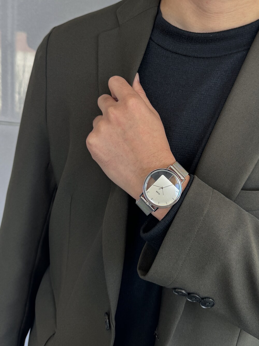 シルバー系のアナログ腕時計を着用したメンズの冬コーディネートの3枚目の写真