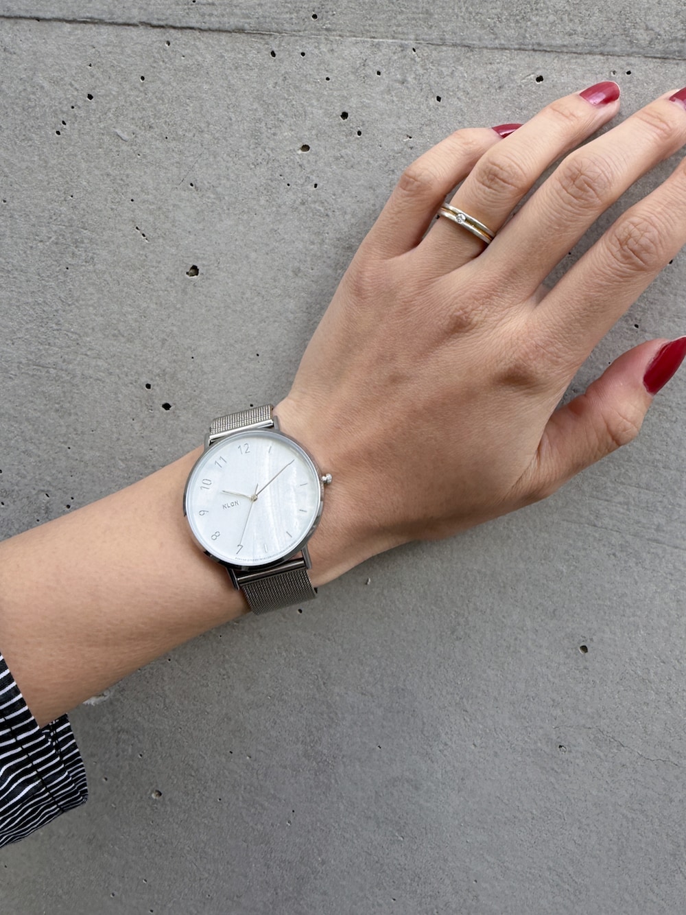 シルバー系のアナログ腕時計を着用したレディースの冬コーディネートの2枚目の写真