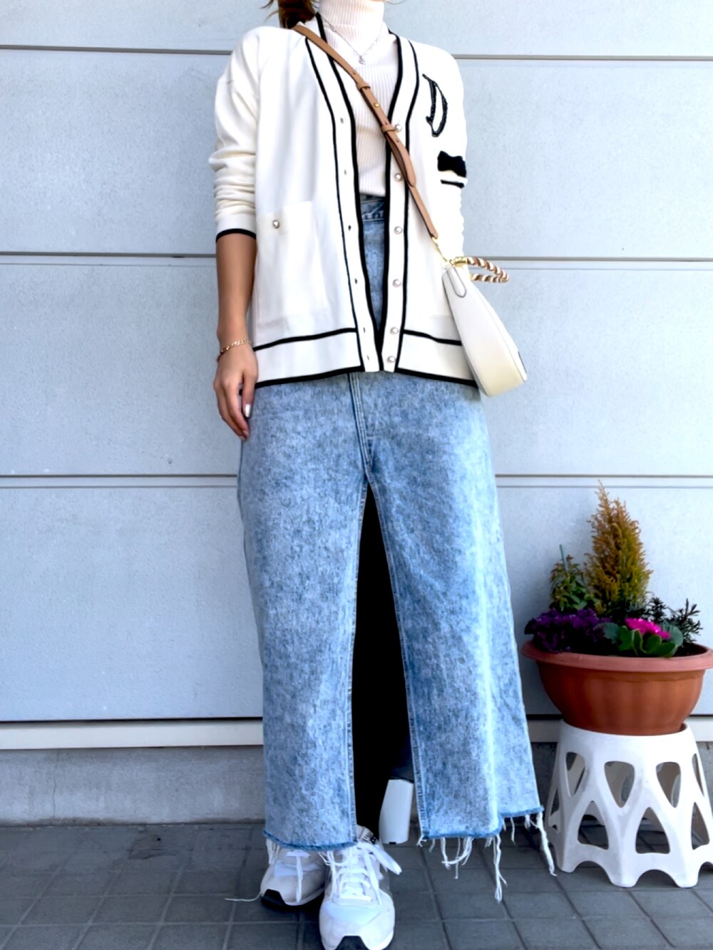 ホワイト系のスニーカー、ブルー系のデニムスカート、ホワイト系のカーディガン/ボレロを着用したレディースの春コーディネートの2枚目の写真
