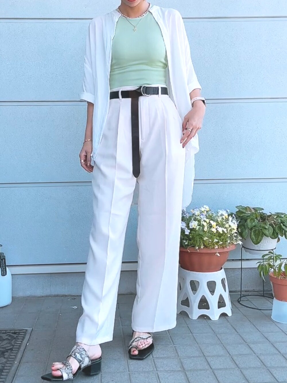 グリーン系のタンクトップ、ホワイト系のシャツ/ブラウス、ホワイト系のスラックスを着用したレディースの春コーディネートの2枚目の写真