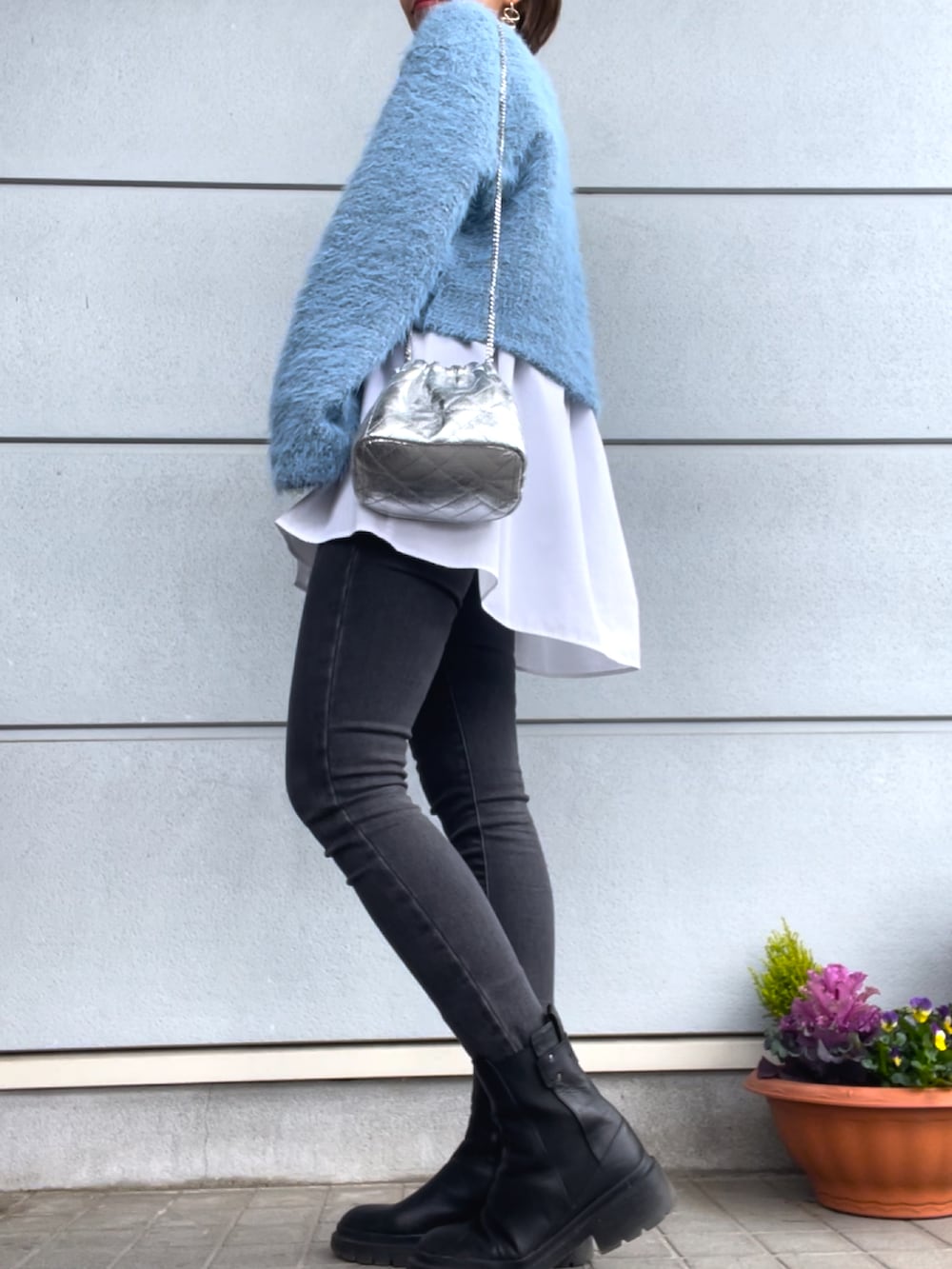 ブルー系のニット/セーター、グレー系のデニムパンツ、ブラック系のブーツを着用したレディースの春コーディネートの2枚目の写真