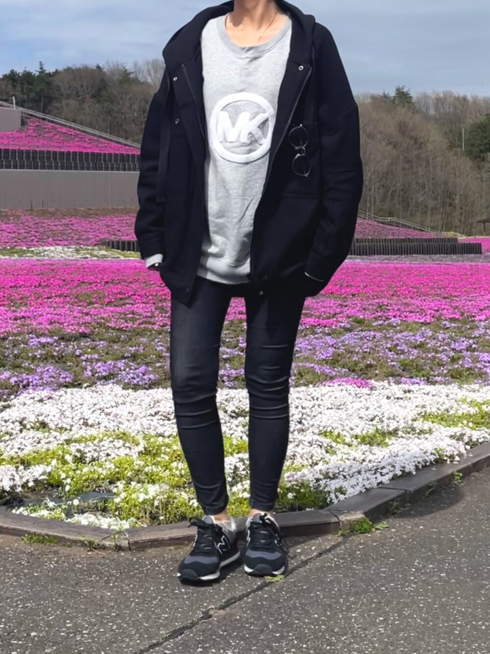 ブラック系のデニムパンツ、グレー系のスウェット、ブラック系のブルゾンを着用したレディースの春コーディネートの3枚目の写真