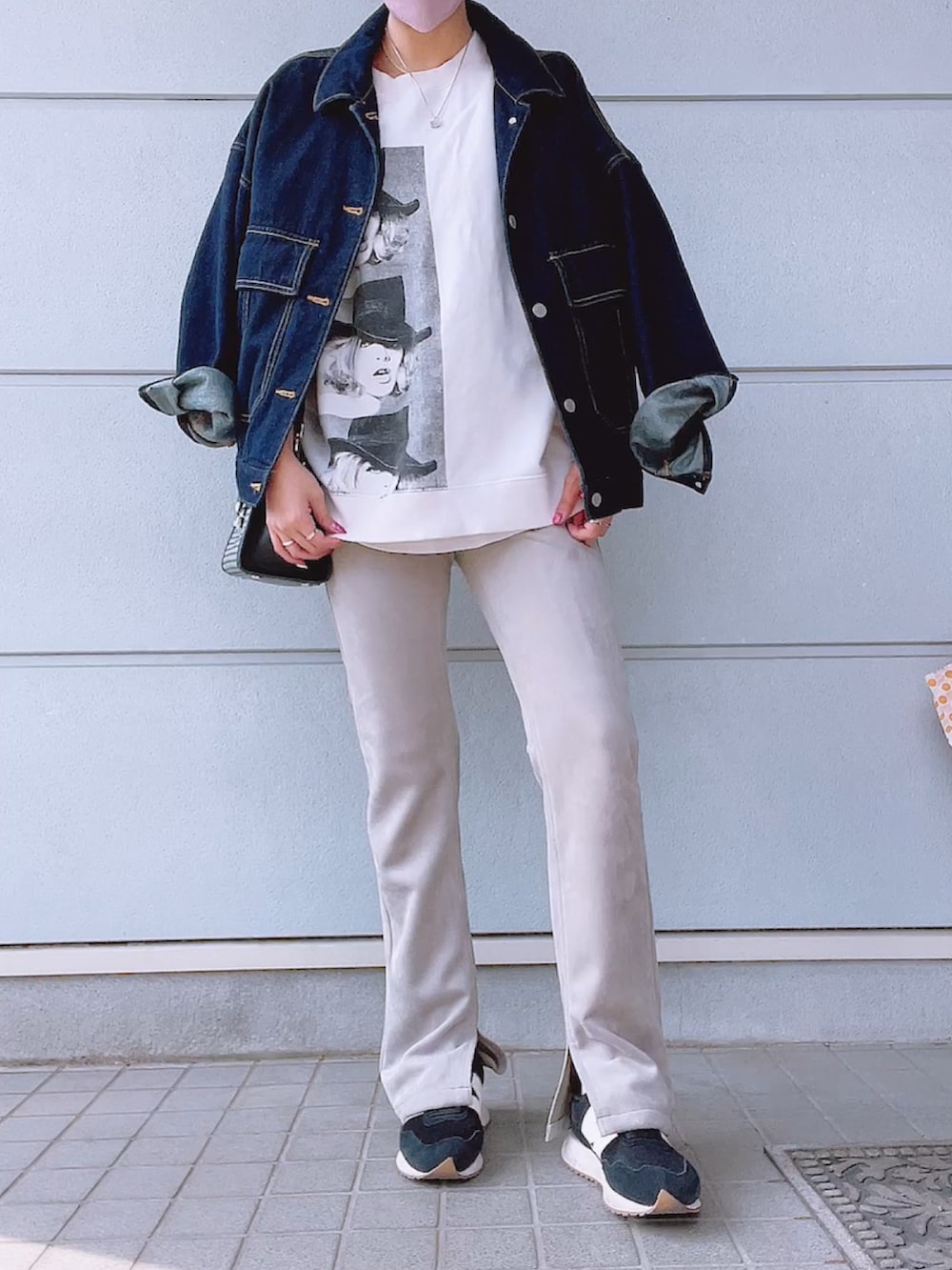 グレー系のパンツ、ブラック系のスニーカー、ホワイト系のスウェットを着用したレディースの春コーディネートの2枚目の写真