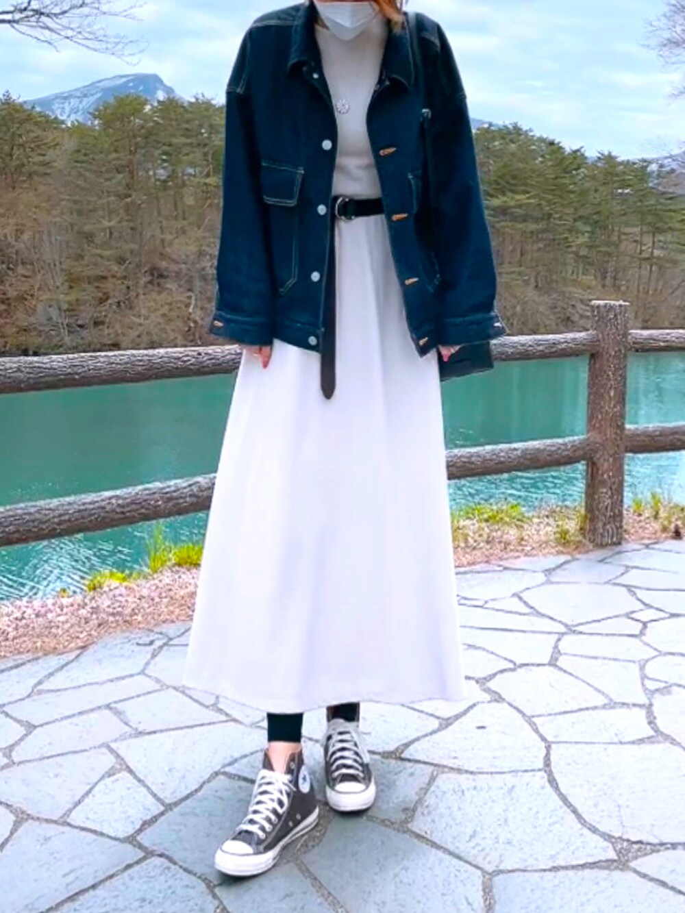 ブラウン系のスニーカー、ホワイト系のワンピース、ブルー系のデニムジャケットを着用したレディースの春コーディネートの2枚目の写真