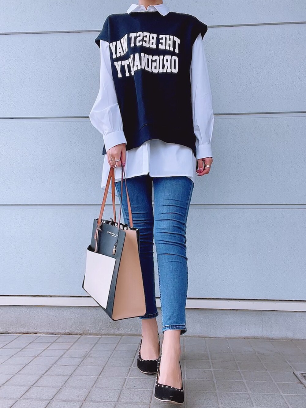 ブルー系のデニムパンツ、ブルー系のトップス、ホワイト系のシャツ/ブラウスを着用したレディースの春コーディネートの2枚目の写真