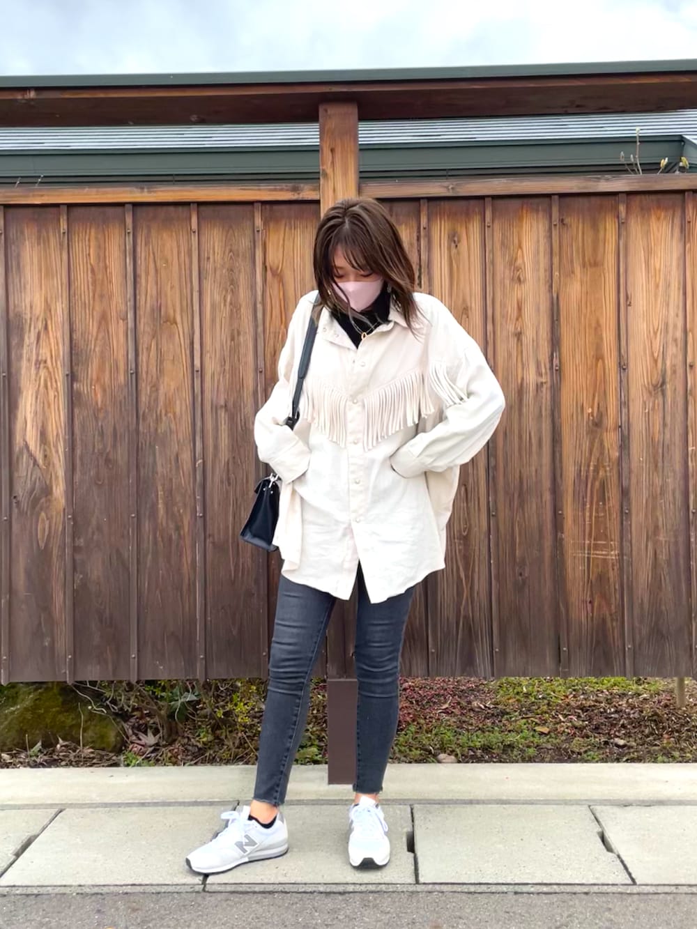 ブラック系のハンドバッグ、ホワイト系のシャツ/ブラウス、グレー系のデニムパンツを着用したレディースの春コーディネートの3枚目の写真