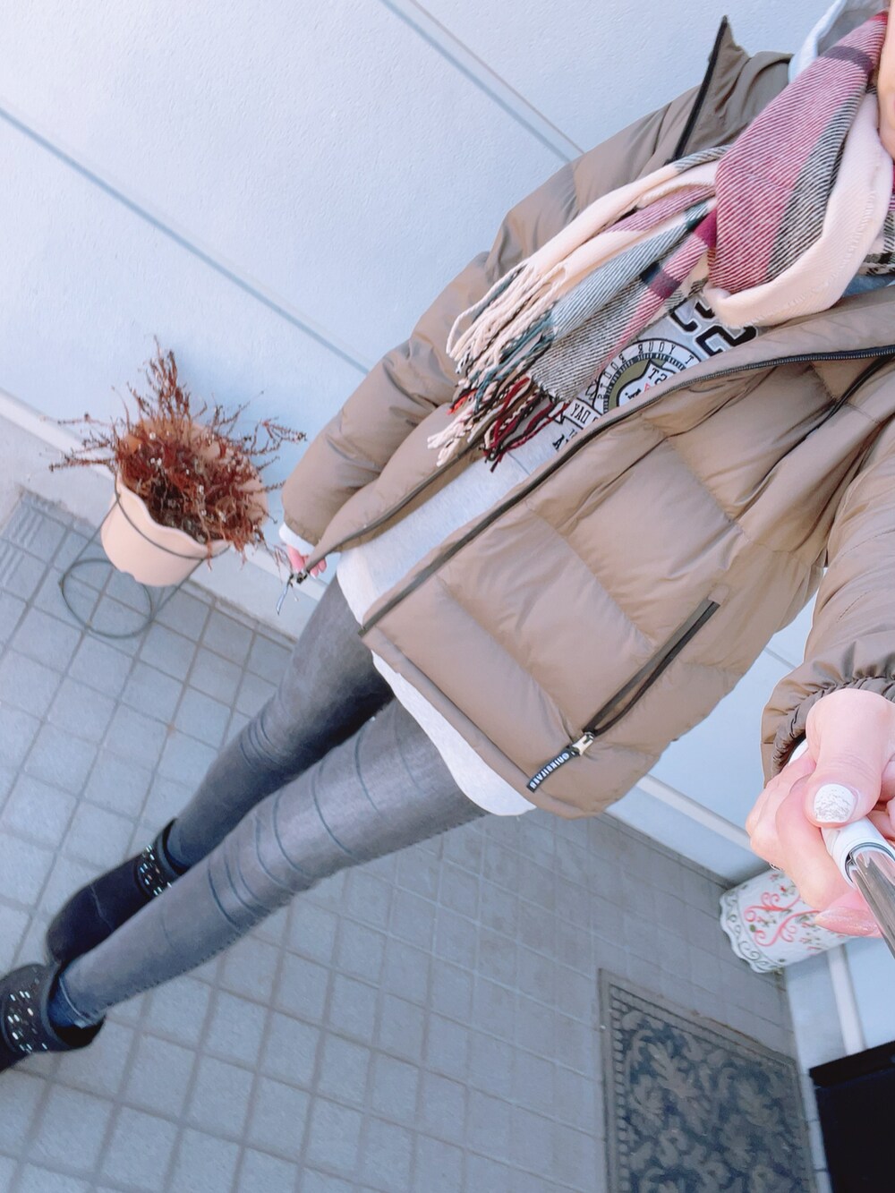 グリーン系のダウンジャケット/コート、グレー系のデニムパンツ、グレー系のパーカーを着用したレディースの冬コーディネートの2枚目の写真