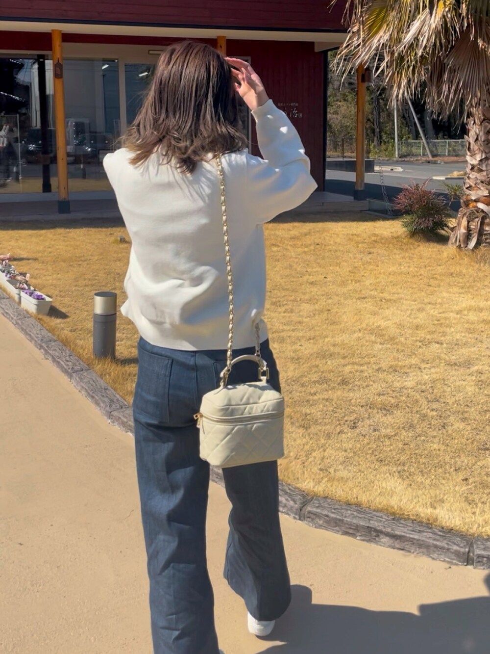 ブルー系のカーディガン/ボレロ、ブルー系のデニムパンツ、ホワイト系のスニーカーを着用したレディースの春コーディネートの2枚目の写真