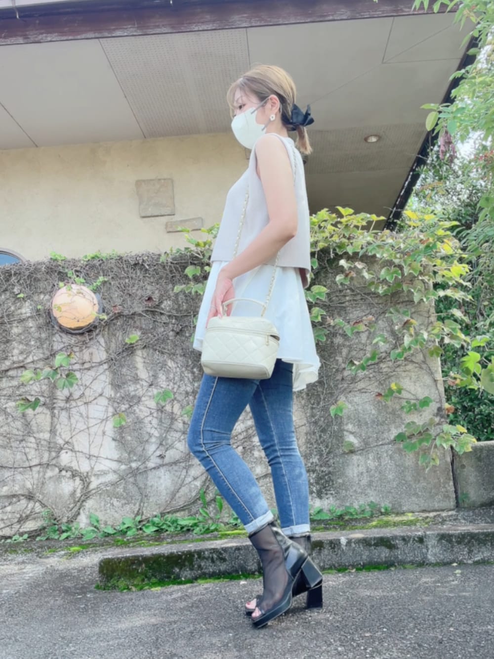 ベージュ系のニット/セーター、ベージュ系のトートバッグ、ブラック系のサンダルを着用したレディースの秋コーディネートの2枚目の写真