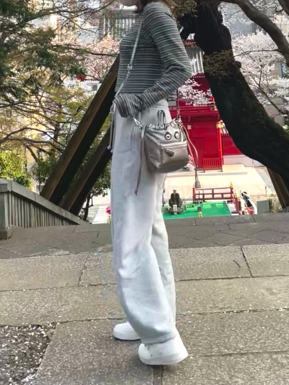 グレー系のスウェットパンツ、ベージュ系のブルゾン、グリーン系のTシャツ/カットソーを着用したレディースの春コーディネートの2枚目の写真