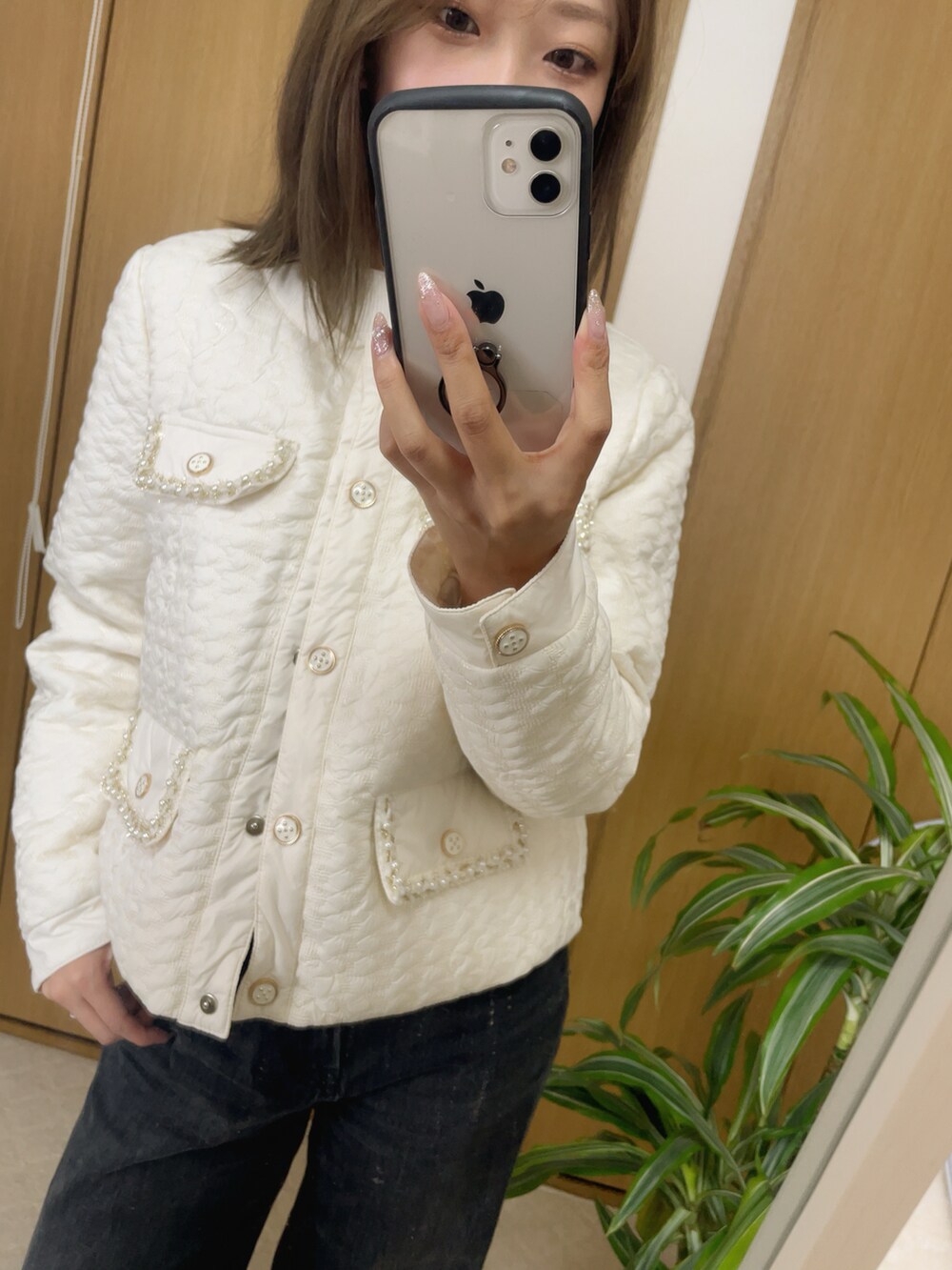 ホワイト系のニット/セーター、ブラック系のデニムパンツを着用したレディースの春コーディネートの2枚目の写真