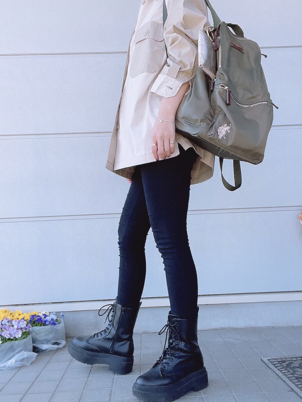 ブラック系のブーツ、ブラック系のパンツ、ベージュ系のトップスを着用したレディースの春コーディネートの2枚目の写真