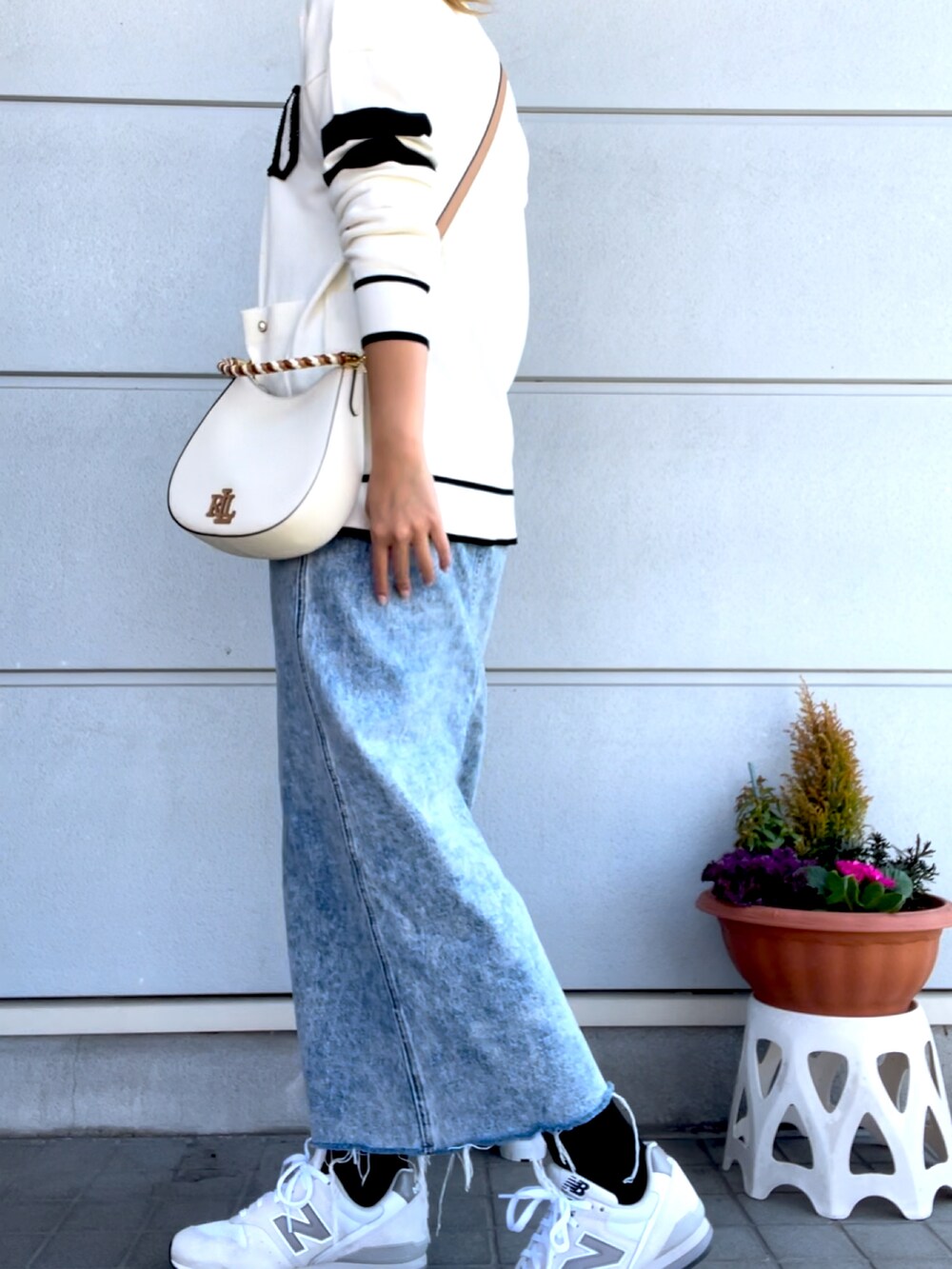 ホワイト系のスニーカー、ブルー系のデニムスカート、ホワイト系のカーディガン/ボレロを着用したレディースの春コーディネートの3枚目の写真