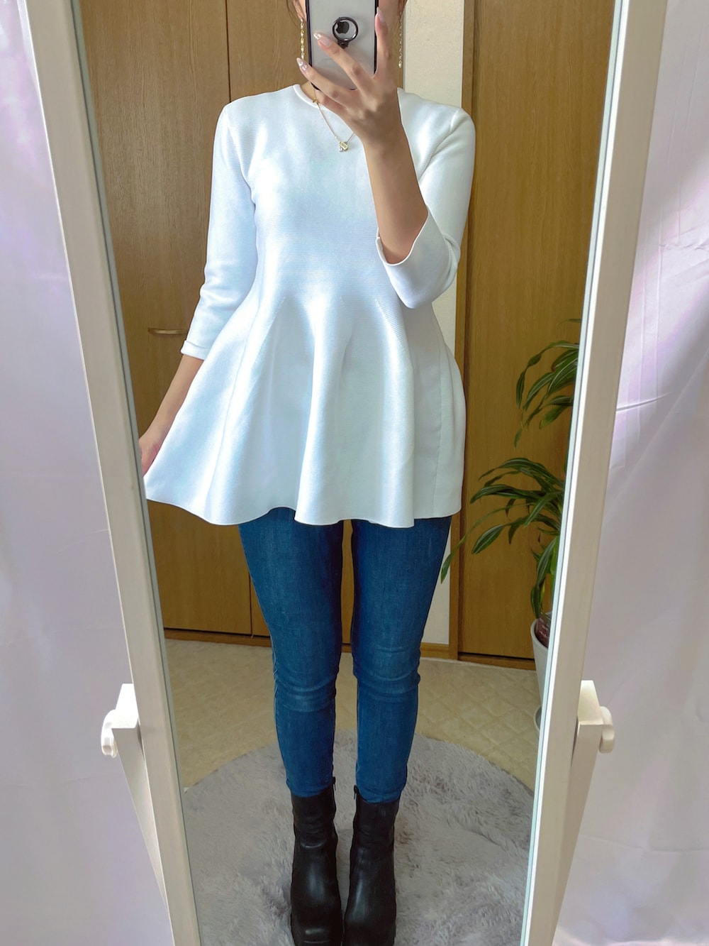 ブラック系のブーティ、ホワイト系のニット/セーター、ベージュ系のニット/セーターを着用したレディースの春コーディネートの2枚目の写真