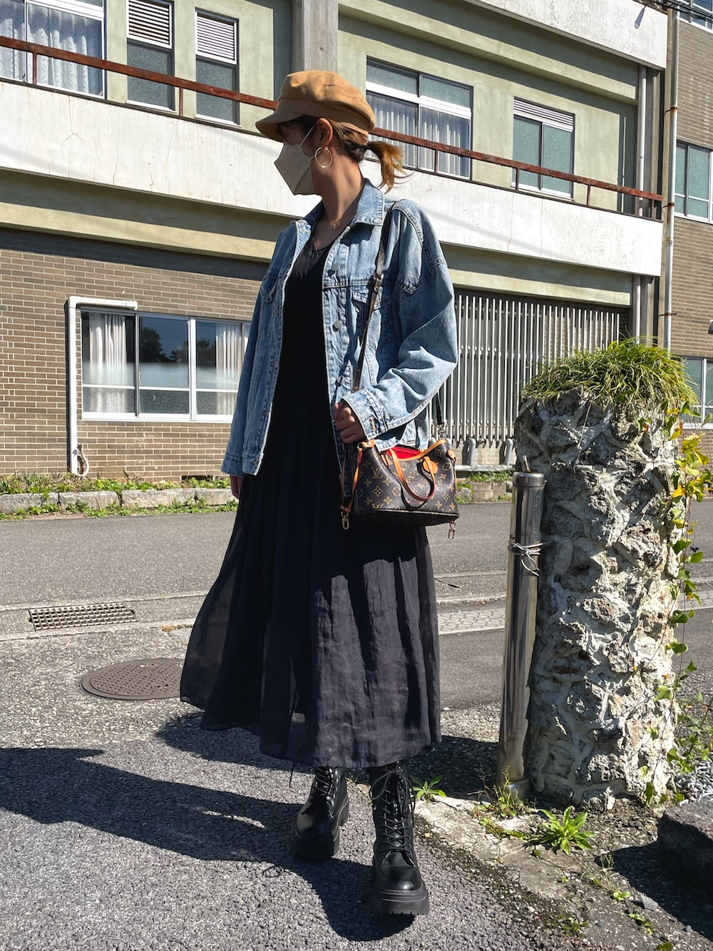 ブルー系のデニムジャケット、ブラック系のワンピース、ベージュ系のキャスケットを着用したレディースの秋コーディネートの2枚目の写真