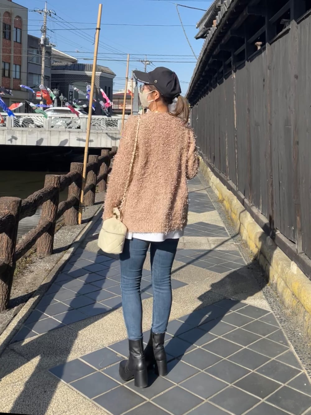 ブラック系のブーティ、ホワイト系のニット/セーター、ベージュ系のニット/セーターを着用したレディースの春コーディネートの4枚目の写真