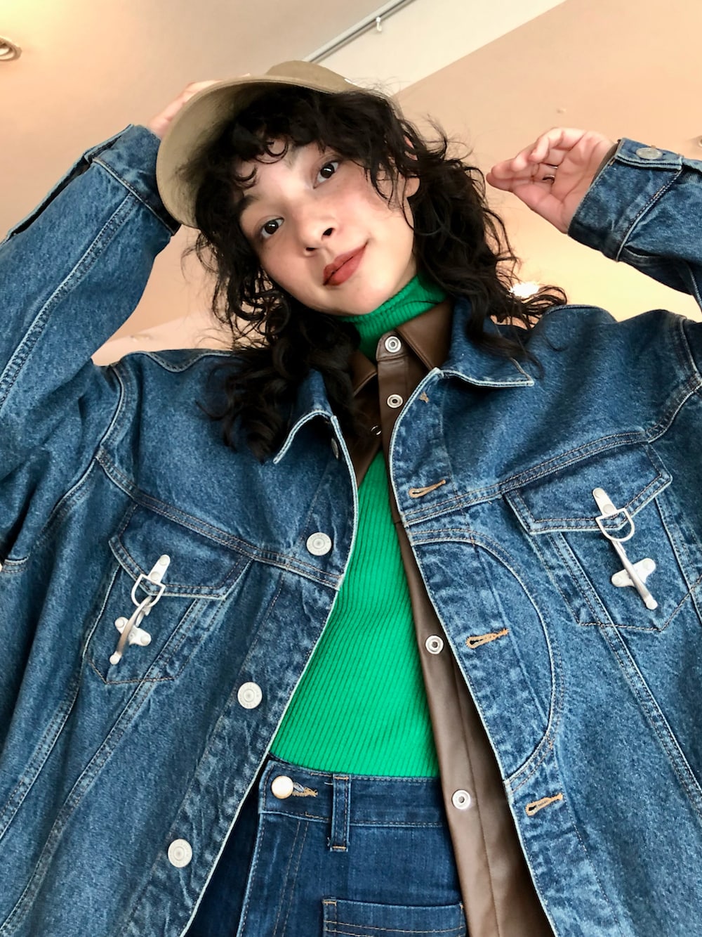 ブルー系のデニムパンツ、ホワイト系のスニーカー、グリーン系のニット/セーターを着用したレディースの冬コーディネートの3枚目の写真