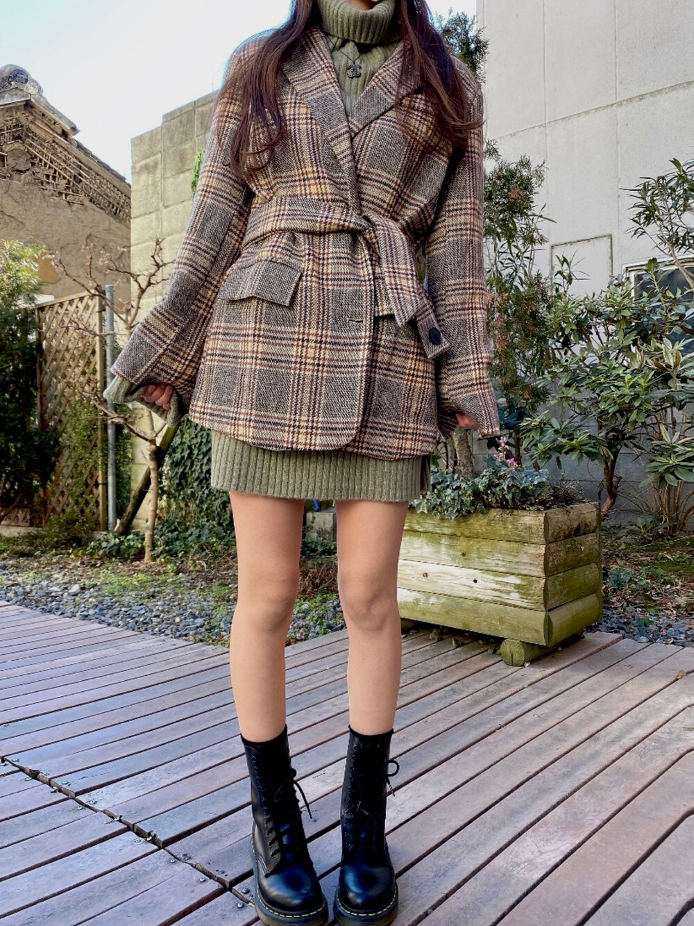 グリーン系のワンピース/ドレス、ブラウン系のジャケット/アウター、ブラック系のバッグを着用したレディースの冬コーディネートの2枚目の写真