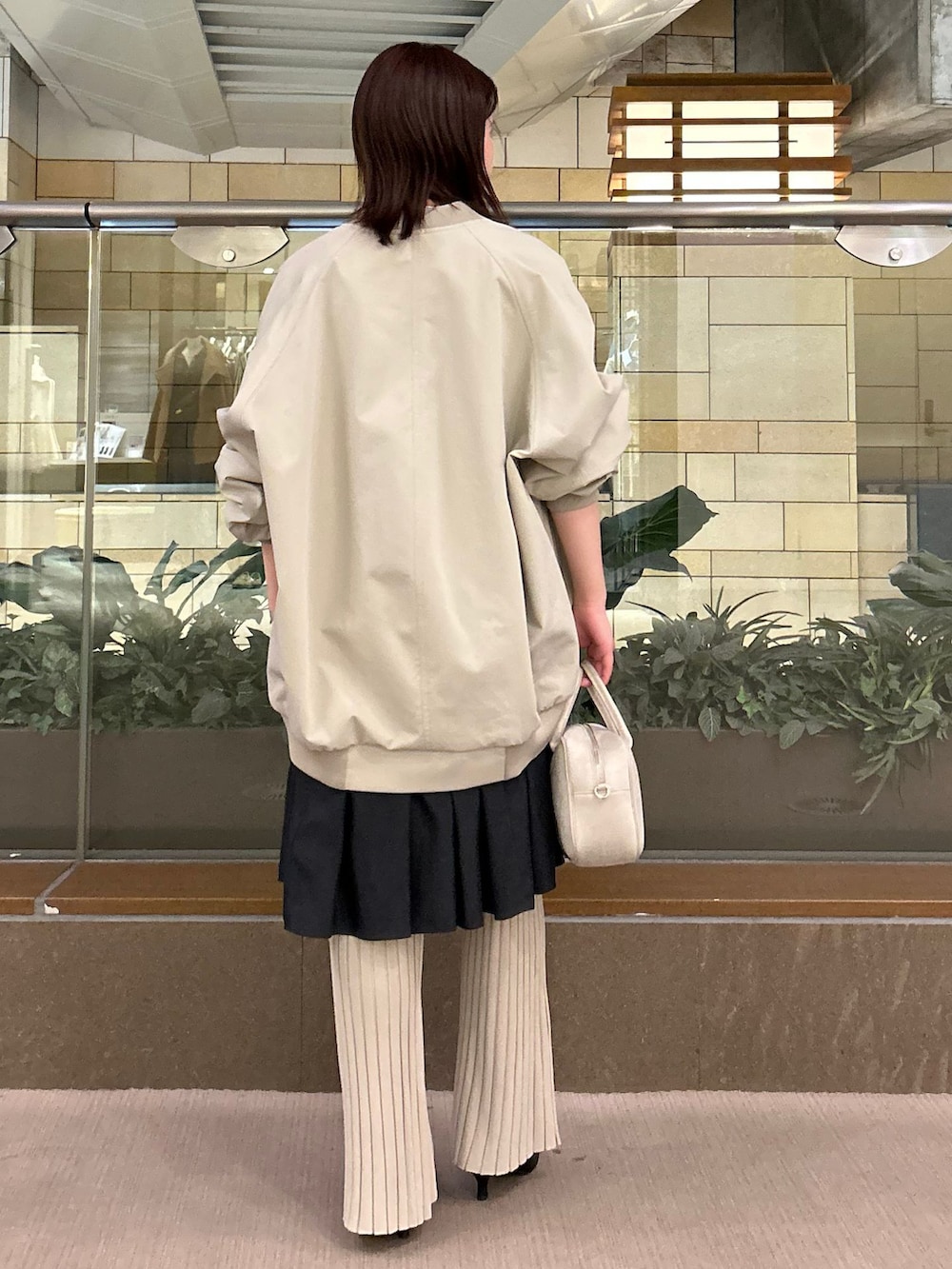 グリーン系のMA-1、ベージュ系のその他パンツ、ブラック系のワンピースを着用したレディースの冬コーディネートの2枚目の写真