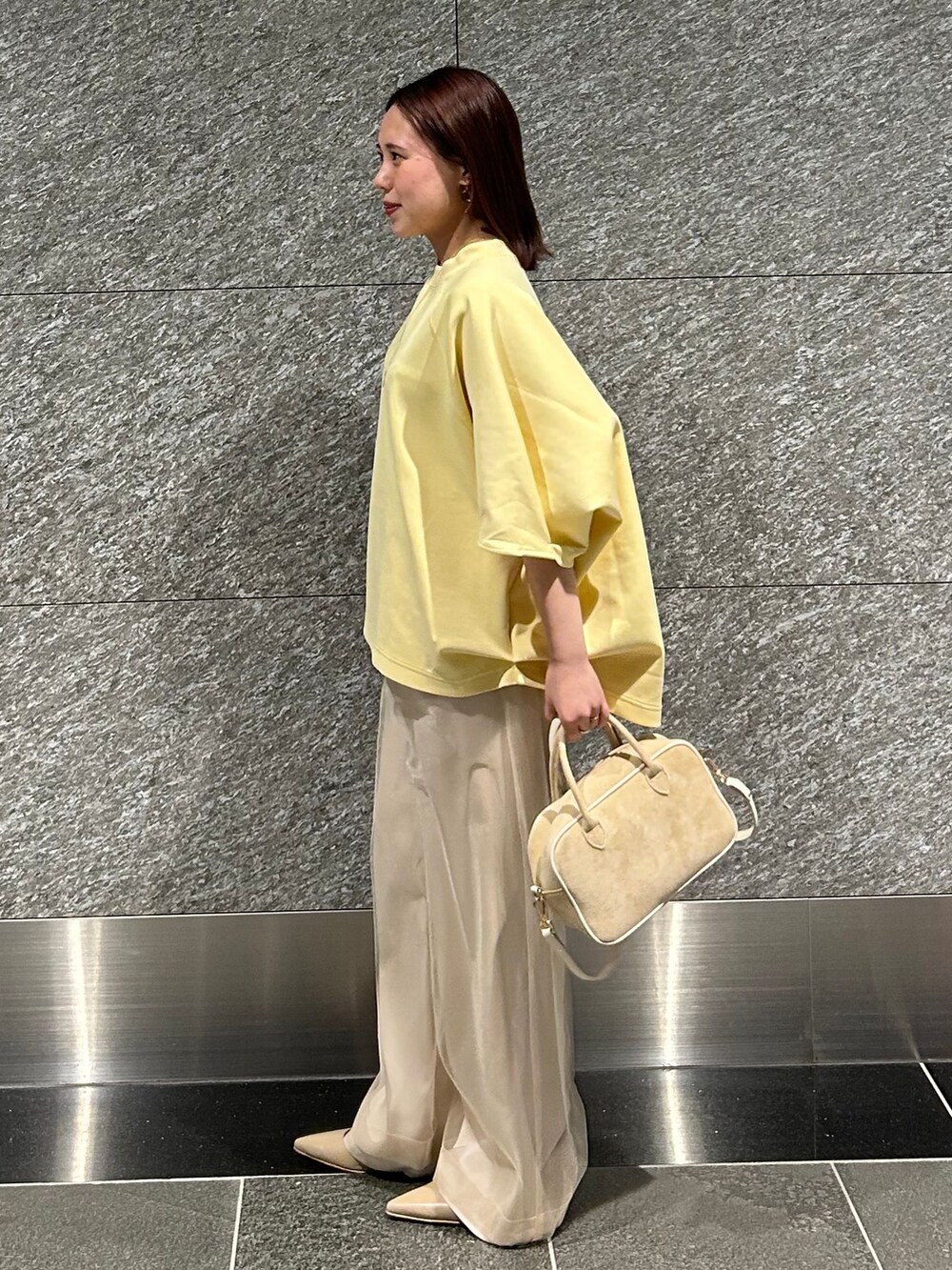 ベージュ系のスラックス、ベージュ系のスラックス、イエロー系のTシャツ/カットソーを着用したレディースの冬コーディネートの2枚目の写真